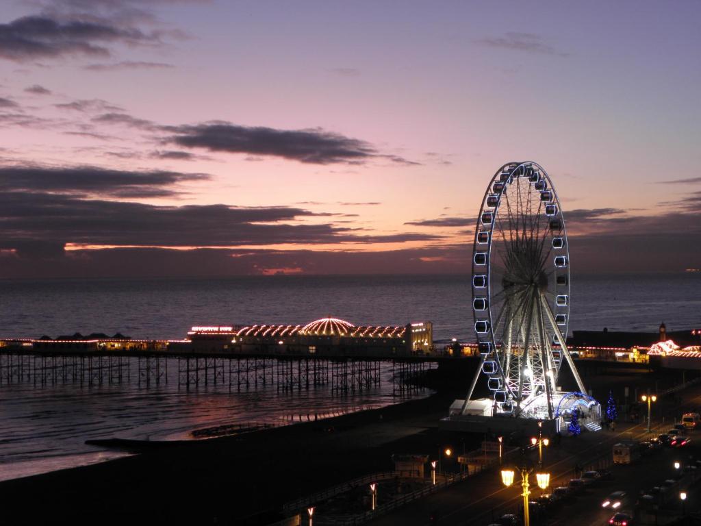 a ferris wheel in front of the ocean at night at Drakes Hotel in Brighton & Hove