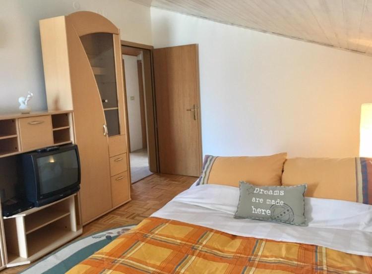 a bedroom with a bed with a pillow and a tv at Villa Saline Apartments Portorož in Portorož