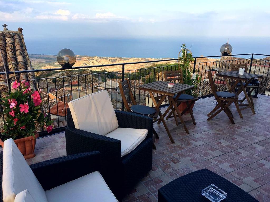 d'un balcon avec des chaises et des tables offrant une vue sur l'océan. dans l'établissement Perla Del Borgo Appartamenti, à Santa Caterina dello Ionio
