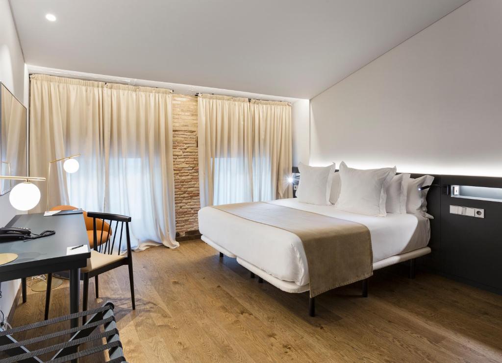 een slaapkamer met een groot wit bed en een bureau bij One Shot Mercat in Valencia