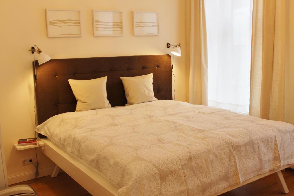 Apartment Creme zentral في بريمين: غرفة نوم بسرير وملاءات بيضاء ونافذة