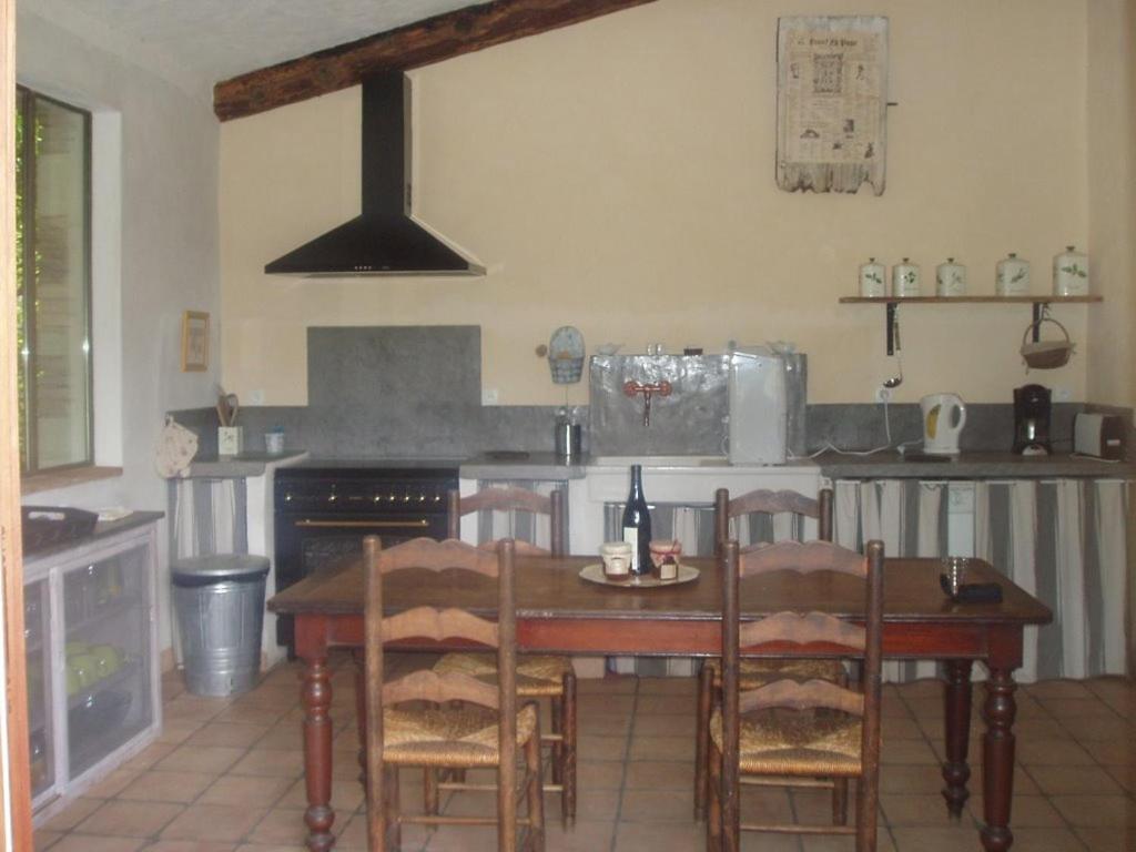 SabranにあるMas de Faviéretteのキッチン(テーブル、椅子、コンロ付)