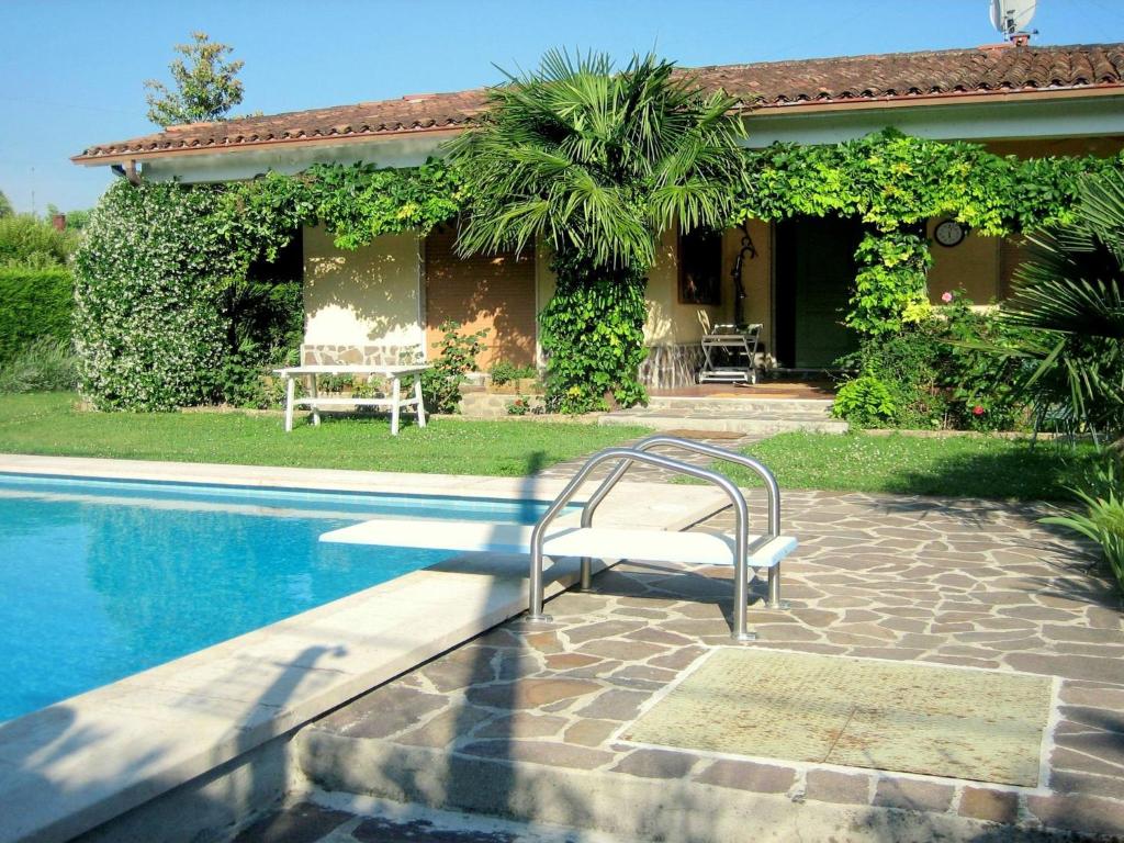 a pool with a chair next to a house at Modern Villa in Lazise with Private Pool in Lazise