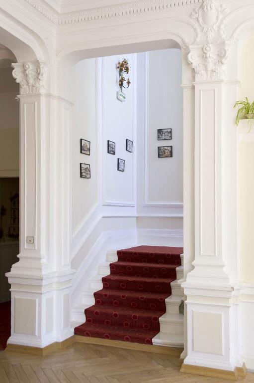 a stairway with white columns and a red carpet at Résidence de Tourisme Vacances Bleues Villa Regina in Arcachon