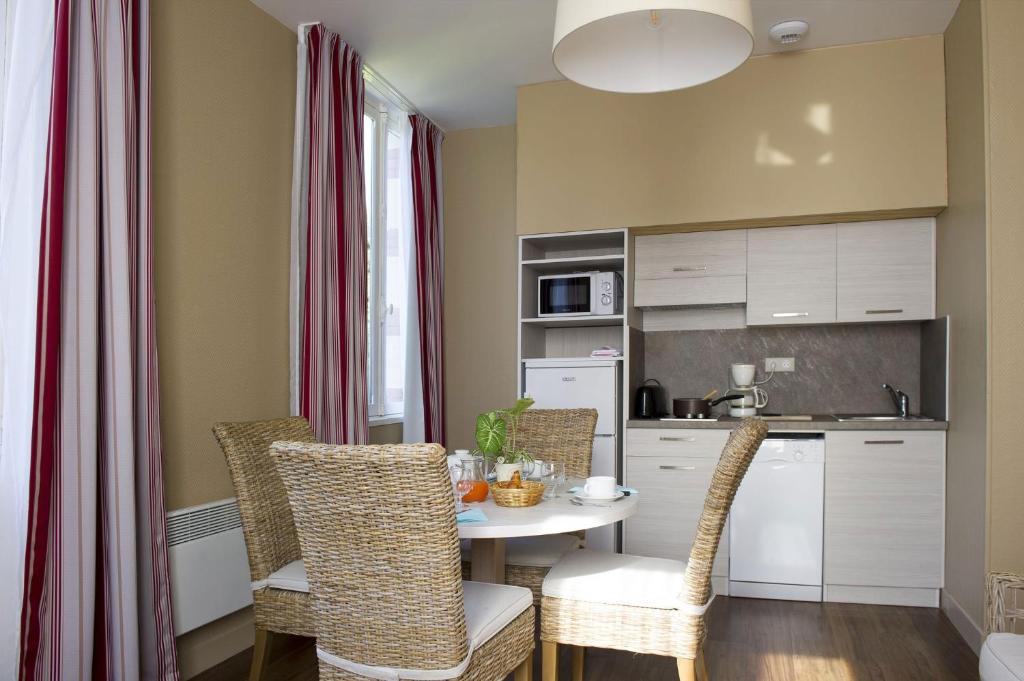 a kitchen with a table and chairs in a room at Résidence de Tourisme Vacances Bleues Villa Regina in Arcachon