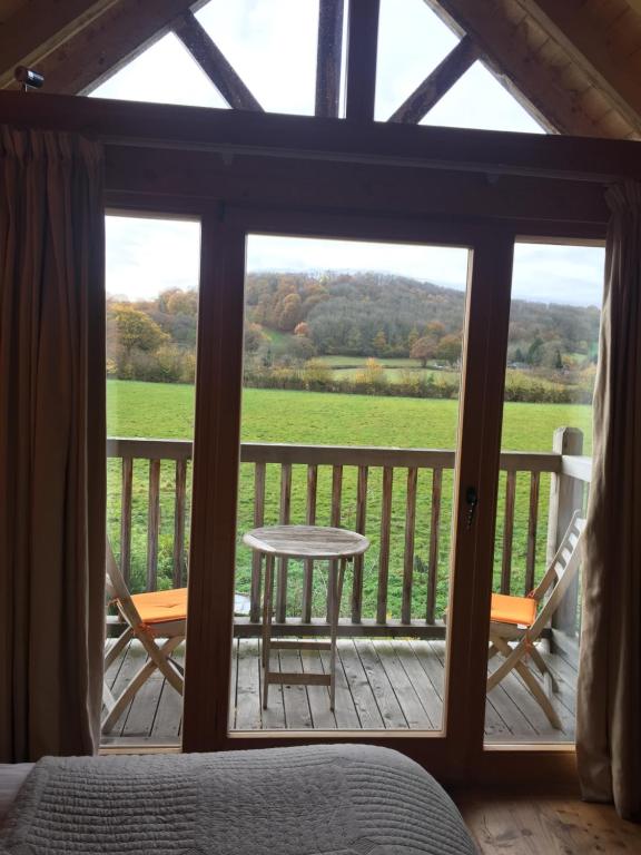 Schlafzimmer mit Blick auf eine Veranda mit einem Tisch und Stühlen in der Unterkunft Pandy B&B in Dorstone