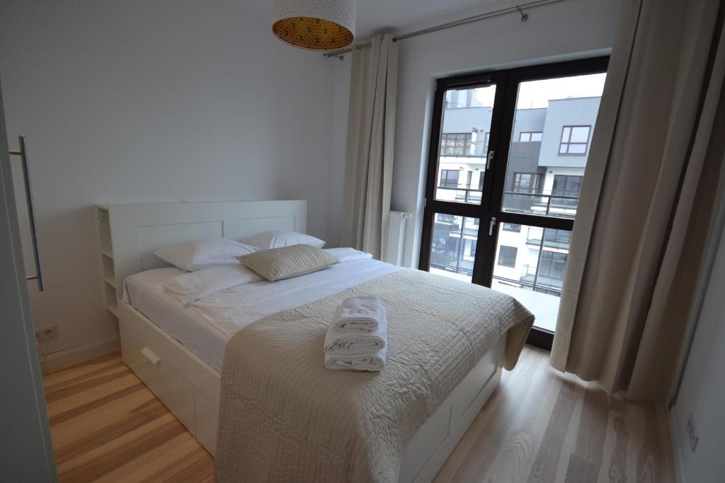ein Schlafzimmer mit einem Bett mit zwei Handtüchern darauf in der Unterkunft NotaBene Apartment in Warschau