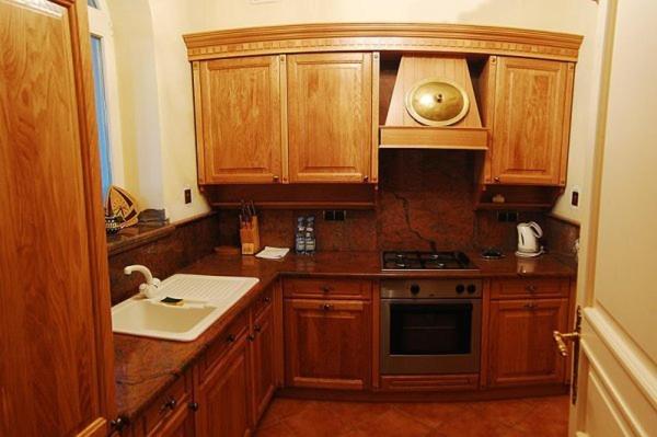 a kitchen with wooden cabinets and a sink at Royal in Kraków