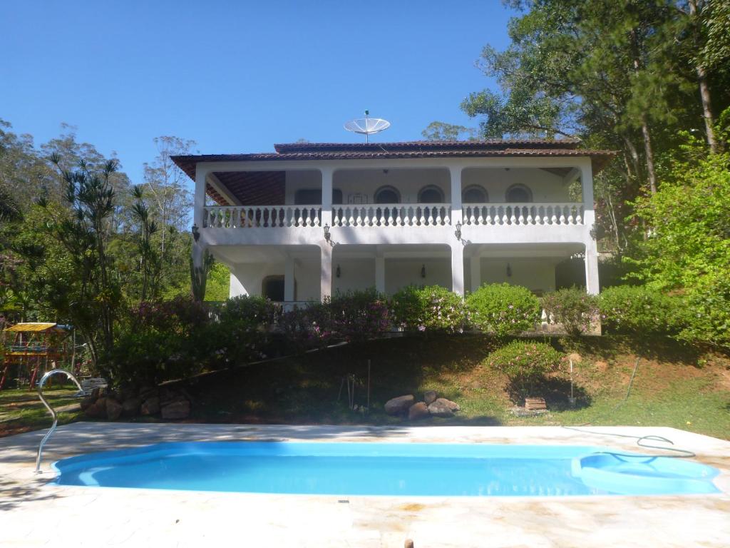 ein Haus mit Pool davor in der Unterkunft Sitio Mogi das Cruzes in Taiaçupeba