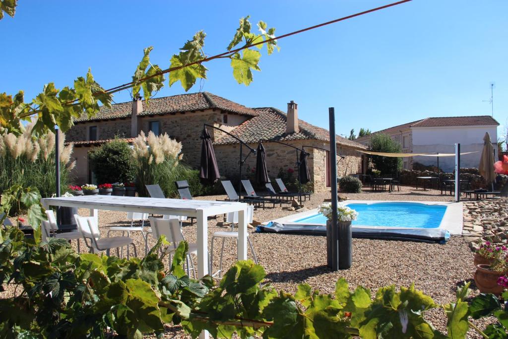 a backyard with a white table and a swimming pool at B&B A ti in Valderrey