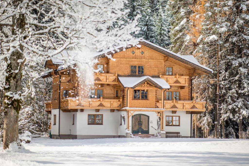 a log home in the woods in the snow at MEINE HEIMAT - Apartments in Ramsau bei Schladming - Skigebiet AMADE in Ramsau am Dachstein