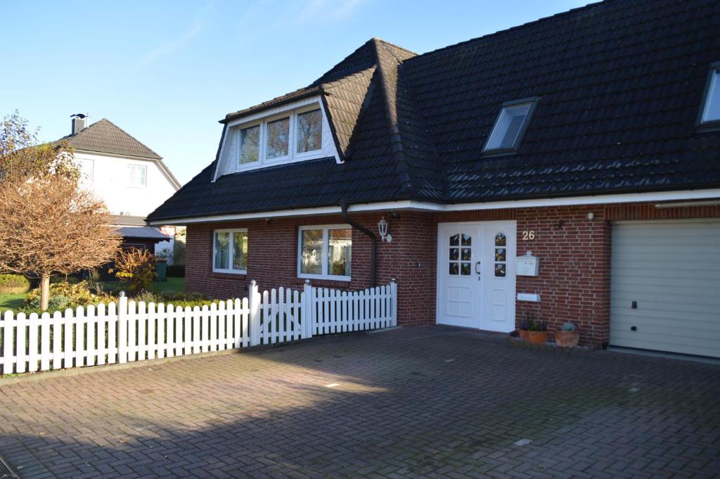 a brick house with a white picket fence at Arkadia-Home-Hamburg-Airport-Apartment in Hamburg