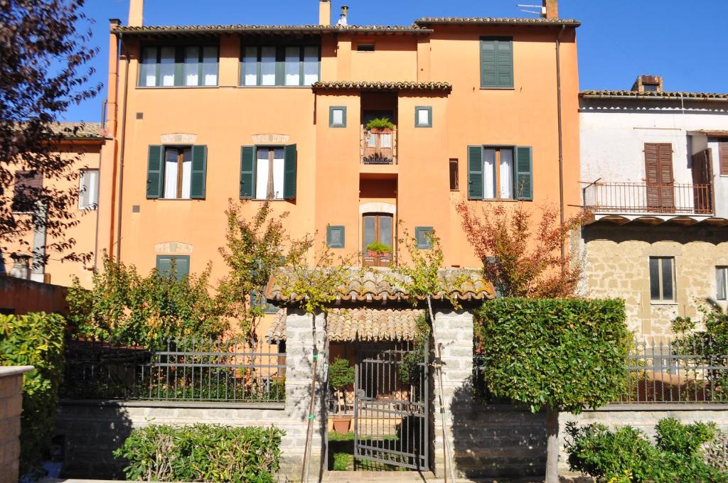 um edifício de apartamentos com uma cerca em frente em Tuscany Location em Marta