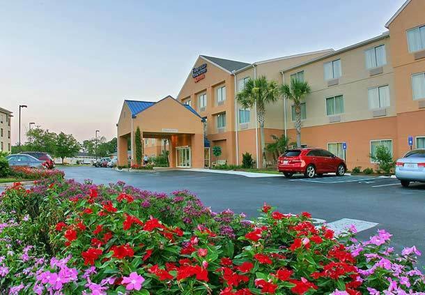 a hotel with flowers in front of a parking lot at Fairfield Inn Suites Brunswick in Brunswick