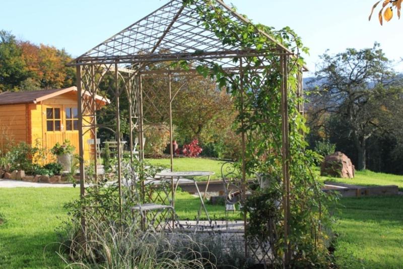 a metal gazebo with a table in a yard at Ferienwohnung im Brennhaus in Freiamt