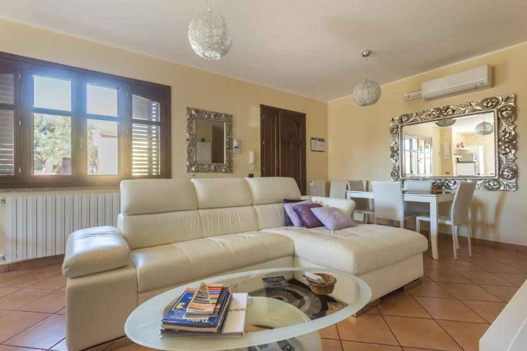 a living room with a white couch and a table at Anaelehouserooms LTB in Arborea