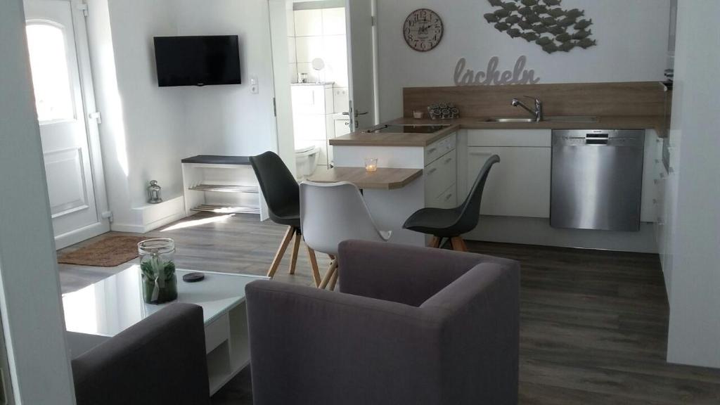 ein Wohnzimmer mit einem Tisch und Stühlen sowie eine Küche in der Unterkunft Landidylle in Bremke