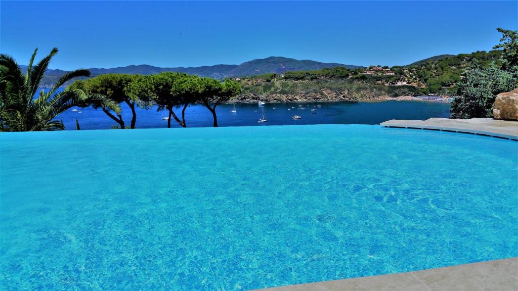 una grande piscina blu con vista sull'acqua di Residence Cala Silente a Capoliveri