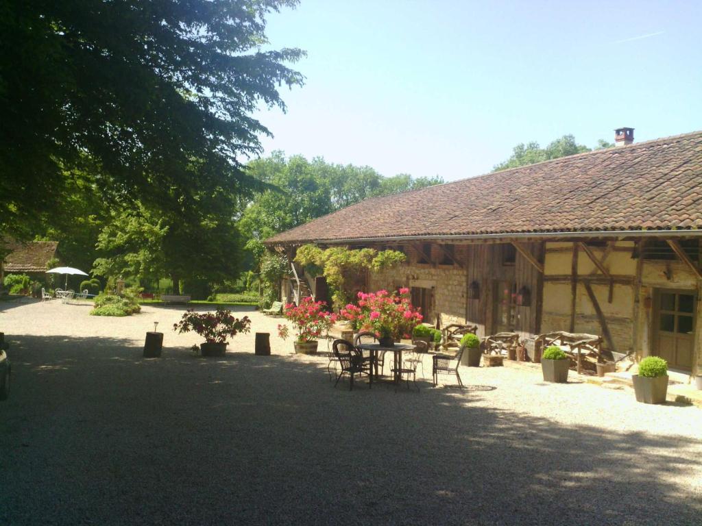 a pavilion with tables and chairs in front of a building at La Ferme de Marie Eugénie in Bruailles