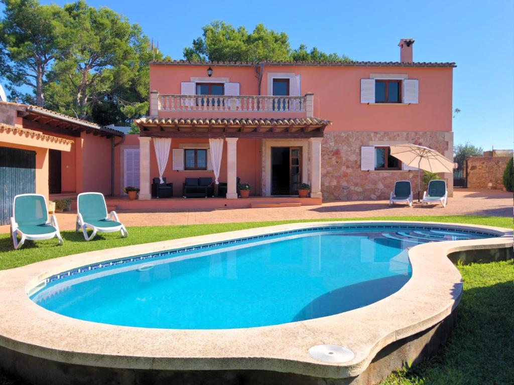 una villa con piscina di fronte a una casa di Villa Natural Barcarés a Alcudia