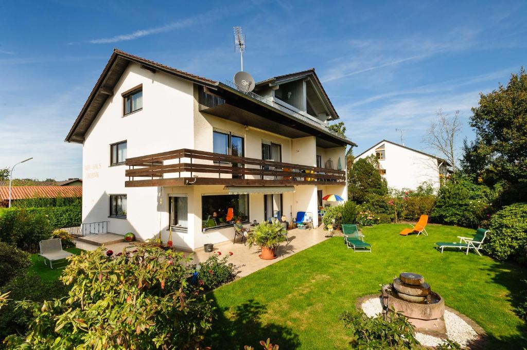 een groot wit huis met een tuin met stoelen bij Appartementhaus Drobnik in Bad Füssing