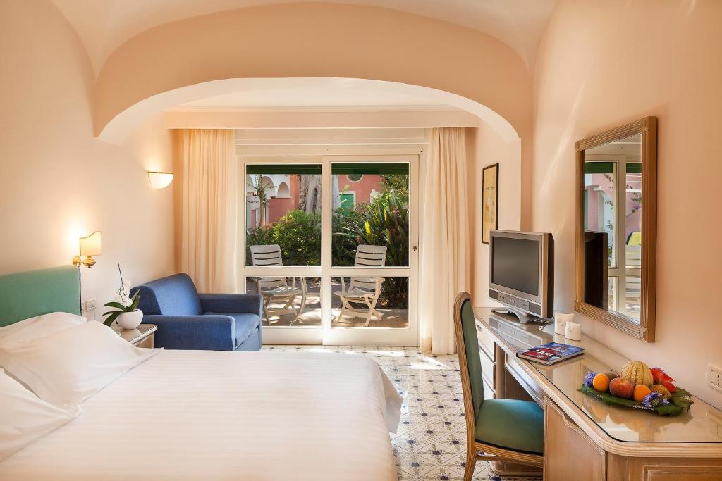 Hotel Continental Ischia في ايسكيا: غرفة فندقية مع سرير ومكتب مع تلفزيون