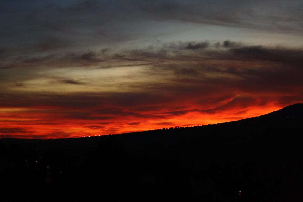 einen Sonnenuntergang über einem Hügel mit rotem Himmel in der Unterkunft A&I Holiday House in Castelnuovo di Porto
