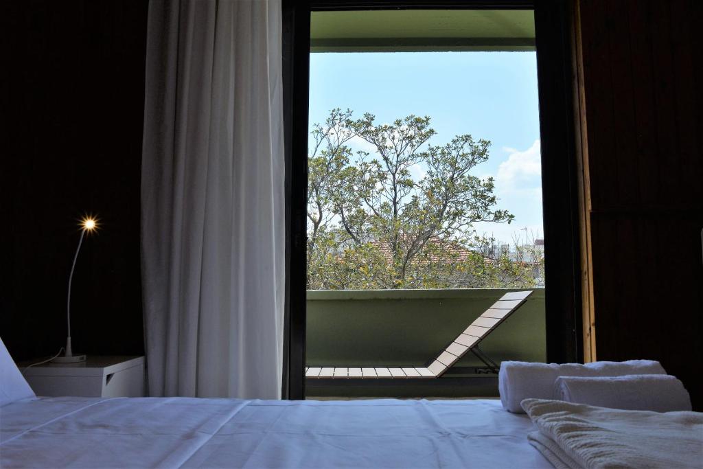 a bedroom with a bed and a large window at Sunhouse-CH in Chania