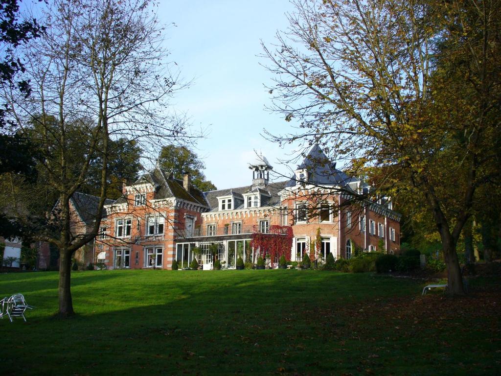 a large house with a large lawn in front of it at Chateau De Hodbomont in Theux