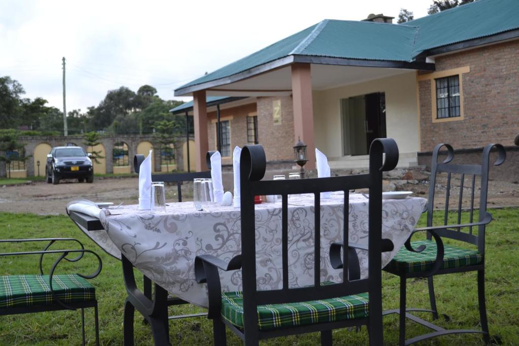une table avec un chiffon de table blanc sur la cour dans l'établissement Zakinn Hotel Gangilonga, à Iringa