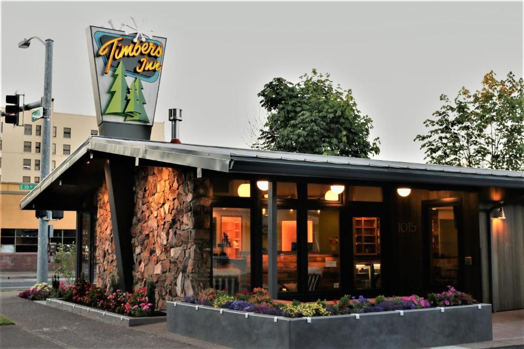 a restaurant with a sign on top of it at Timbers Inn in Eugene