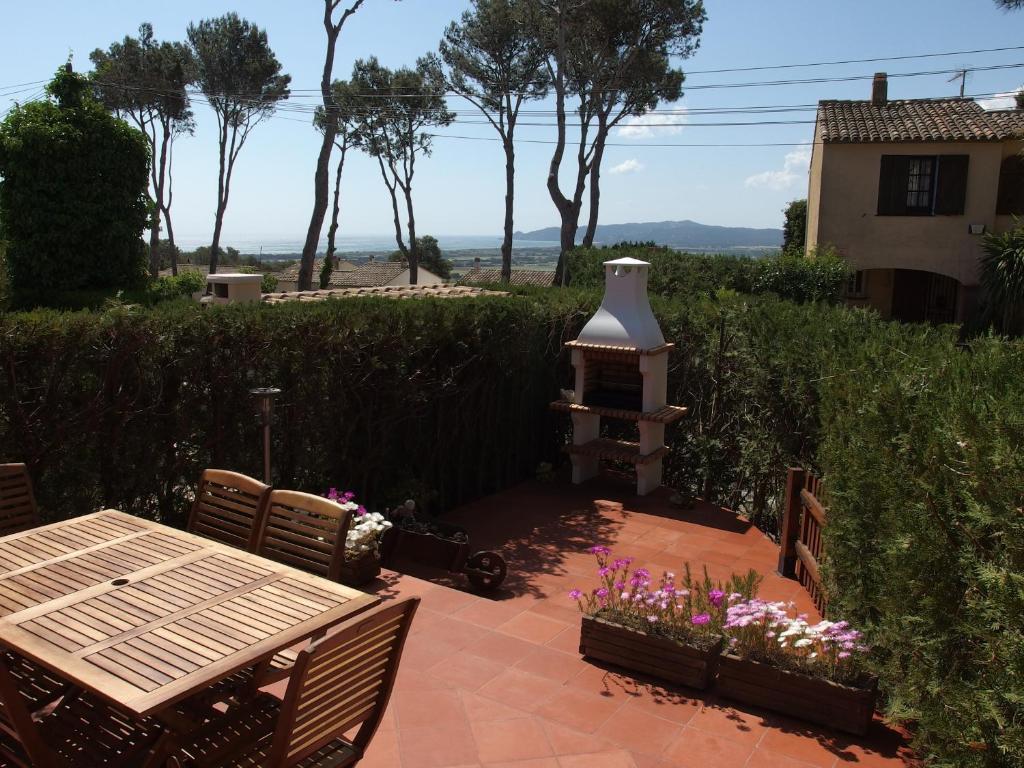 une terrasse avec une table en bois et une cheminée dans l'établissement Casa Atenes, à L'Estartit