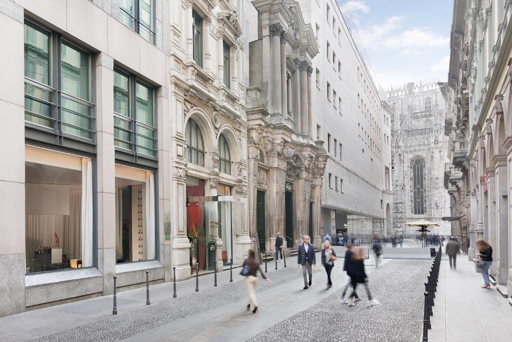 un grupo de personas caminando por una calle de la ciudad en Sina The Gray, en Milán