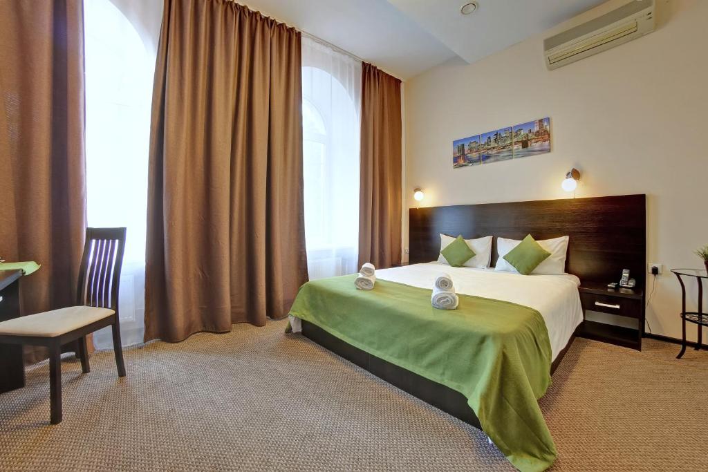a hotel room with a bed and a desk and window at Sfera hotel Nevsky 163 in Saint Petersburg