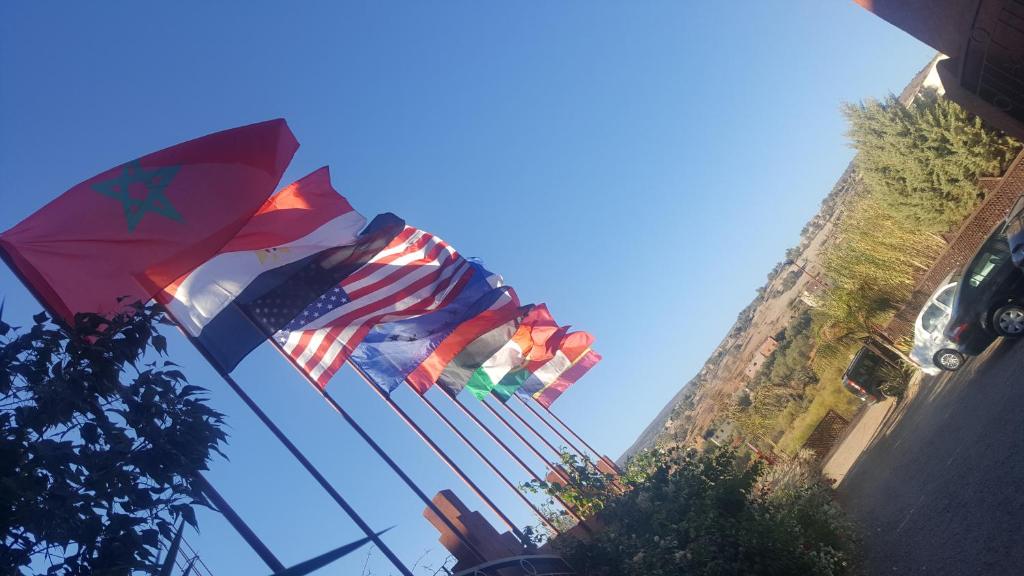 three american flags on a pole next to a building at Hôtel Ajil Cascades D'ouzoud in Ouzoud