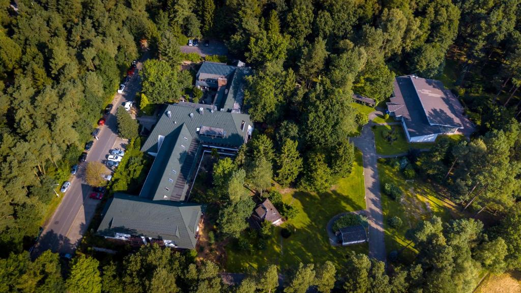 an aerial view of a large house in the forest at Hotel Zur Heidschnucke in Asendorf