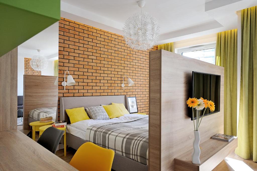 sypialnia z łóżkiem i ceglaną ścianą w obiekcie JTB Nautica Aparthotel w Szczecinie