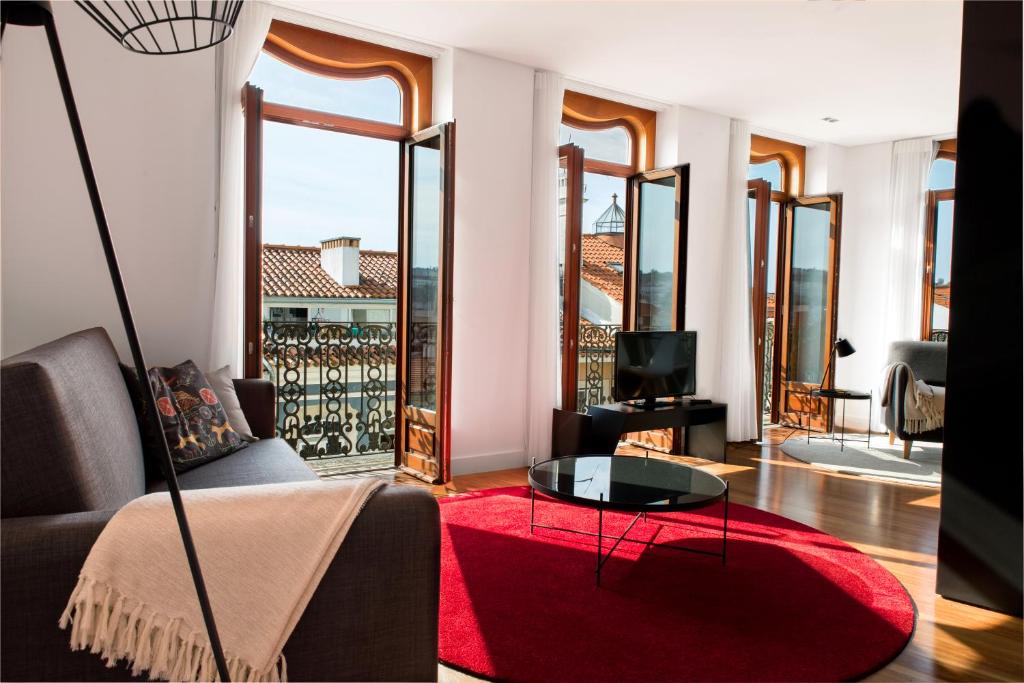 a living room with a couch and a red rug at Orpheus - Isabel de Aragão - UNESCO Heritage in Coimbra