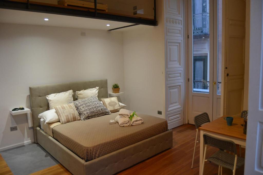 サレルノにあるVia Roma Apartment Deluxeのテーブル付きの部屋にベッド付きのベッドルームがあります。