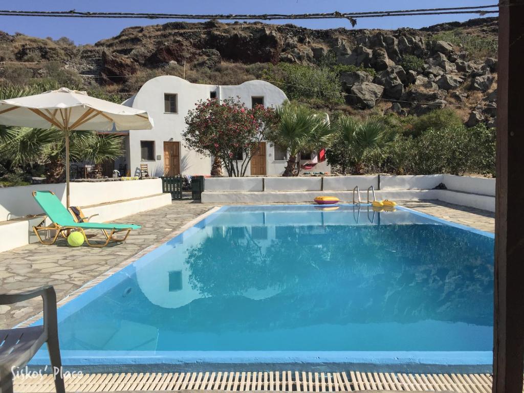 a swimming pool with a villa in the background at Siskosplace in Oia