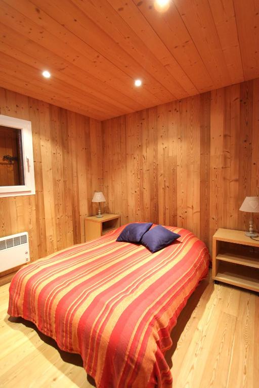 a bedroom with a bed in a wooden room at Chalet Barcelonnette in Barcelonnette
