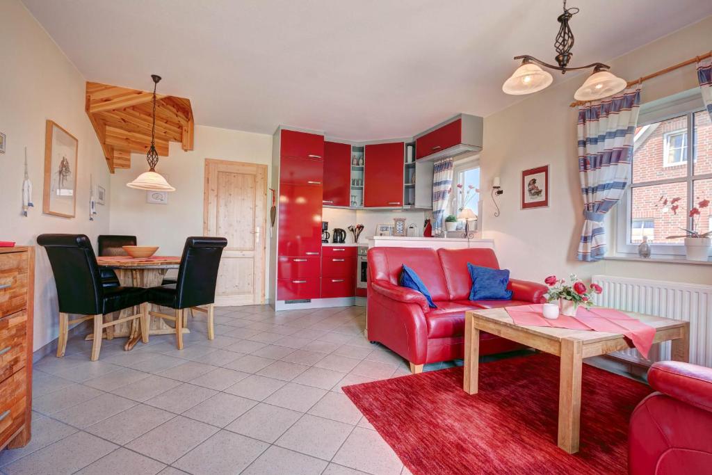 ブットヤーディンゲンにあるParadies-Ferien Burhave - Kat. IIのリビングルーム(赤いソファ、テーブル付)