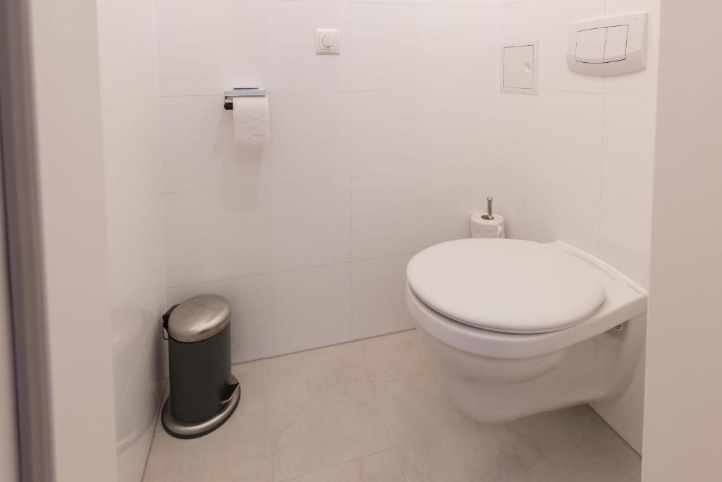 biała łazienka z toaletą i koszem na śmieci w obiekcie Stunning Apartment Vienna Central Station w Wiedniu