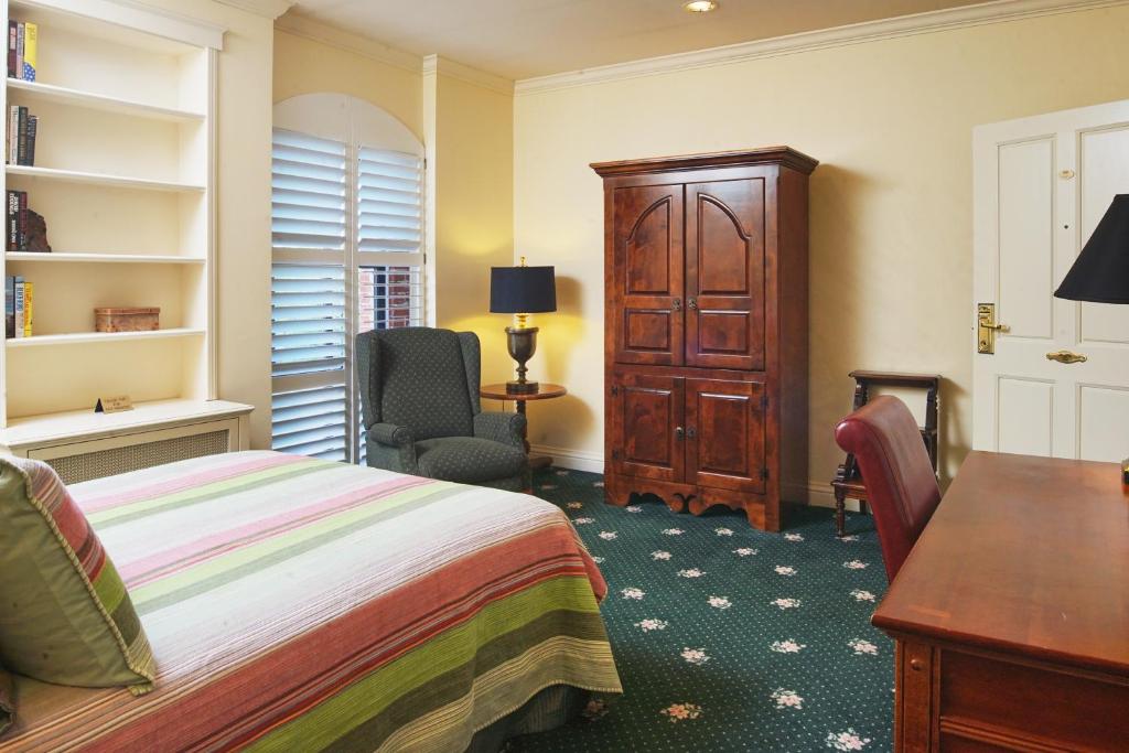 a bedroom with a bed and a desk and a chair at Hotel Mac in Richmond