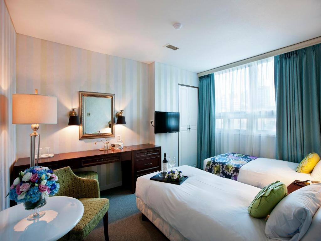 Pokój hotelowy z 2 łóżkami i biurkiem w obiekcie Central Tourist Hotel w Seulu