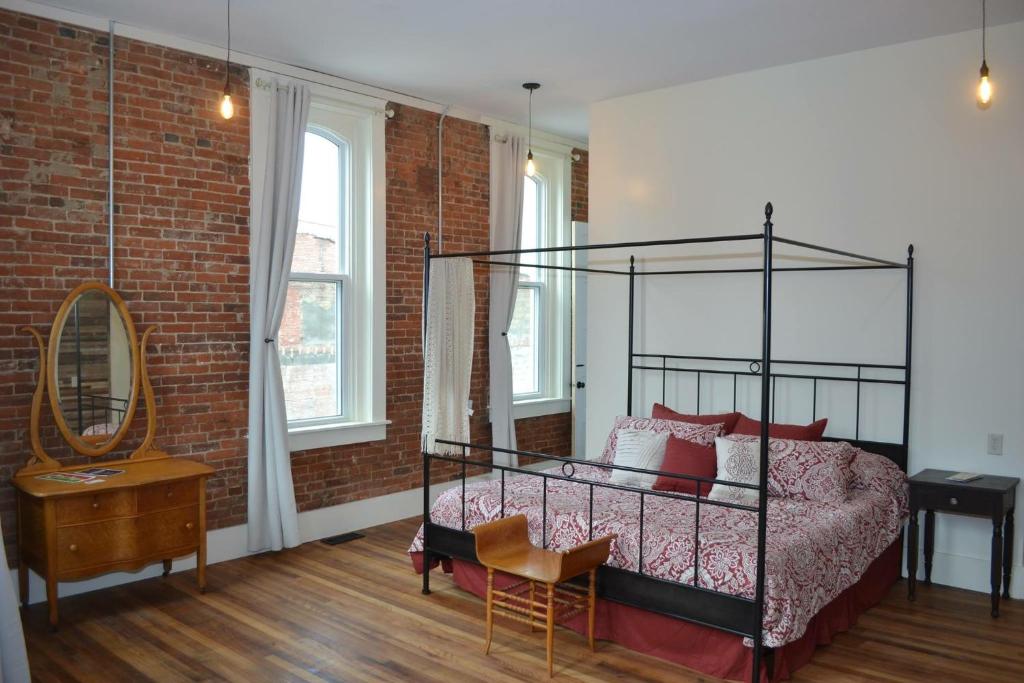 um quarto com uma cama e uma parede de tijolos em Eighteen-Ninety Sleepover em Casey