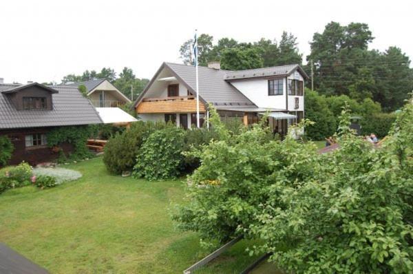 une maison avec une cour ornée de buissons et d'arbres dans l'établissement Laane Pansion, à Käsmu