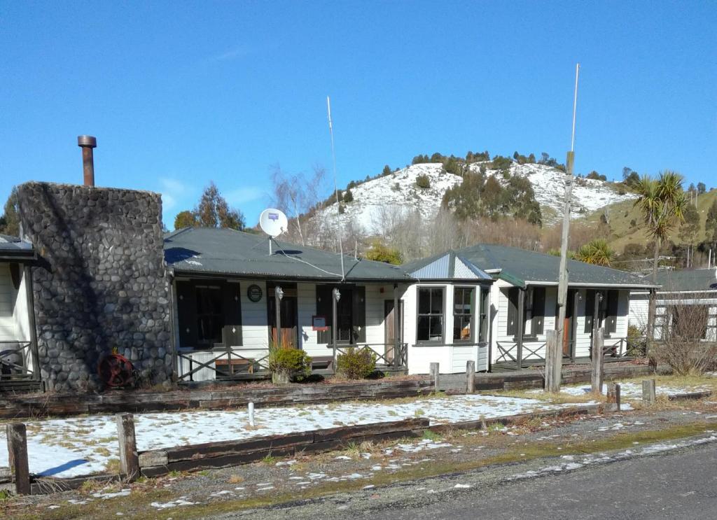 een wit huis met een berg op de achtergrond bij Slalom Lodge in Raurimu Spiral