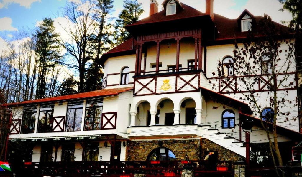 a large white building with a clock on it at Pensiunea Alex in Sinaia