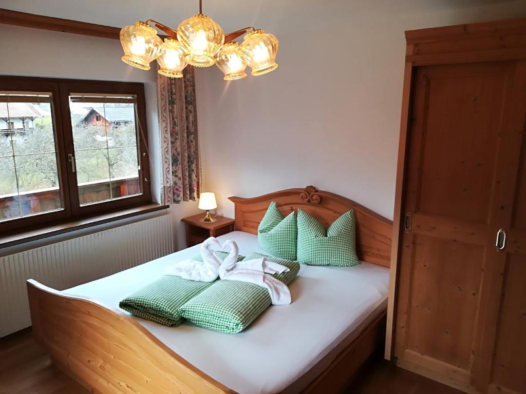 Un dormitorio con una cama con almohadas verdes y blancas. en Ferienhaus Gundolf Christine & Peter, en Arzl im Pitztal